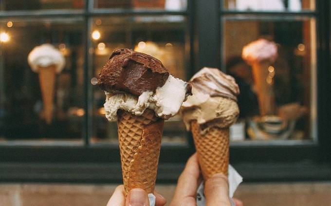 Duas mãos segurando dois cones de sorvete