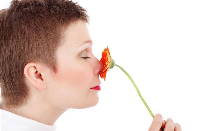 mulher cheirando flor