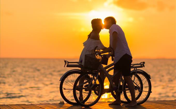 casal em bicicletas se beijando