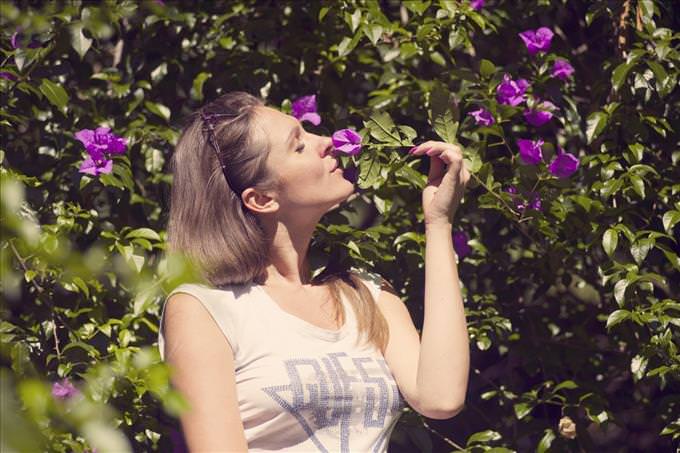 mulher cheirando uma flor violeta