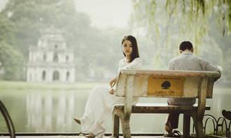 Jogo dos Erros: casal sentado no banco em frente ao lago