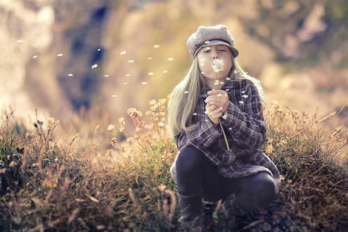 A girl blowing on a dandelion