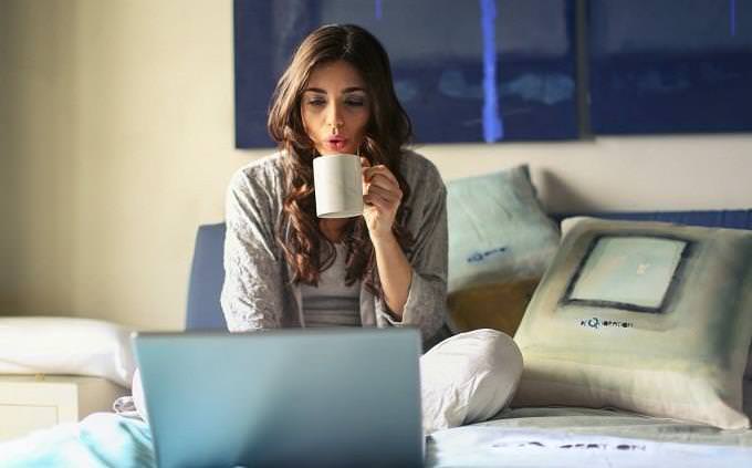 woman with cup of coffee looking at screen