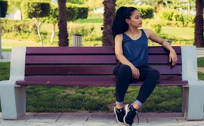 woman sitting in sports clothes on a bench