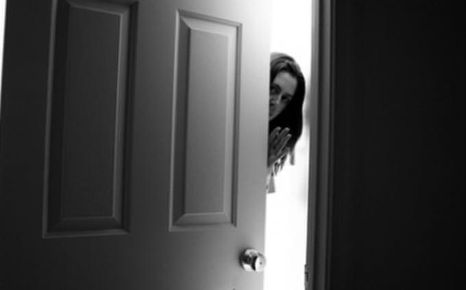 woman slowly opening door