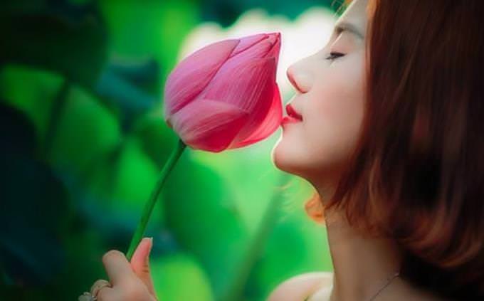 mulher cheirando uma flor