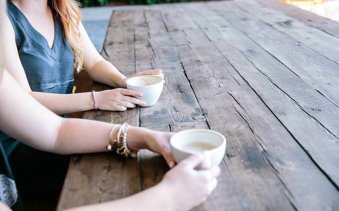 the hands of two women having coffee together