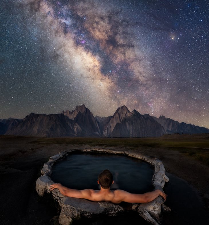 Astronomy photographs of the night sky and nightscapes by Marcin Zajac, man in hot tub looks at the Milky way in the Eastern Sierras, admiring the milky way