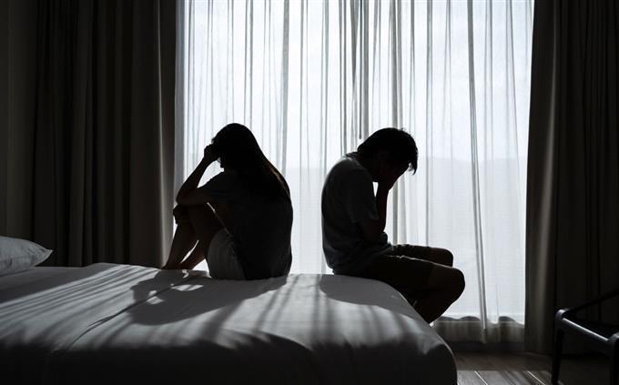 Teste de Relacionamento Tóxico: Um homem e uma mulher em uma cama de costas um para o outro