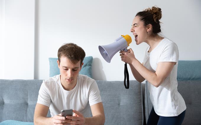 Teste de relacionamento tóxico: uma mulher grita com um homem com um megafone