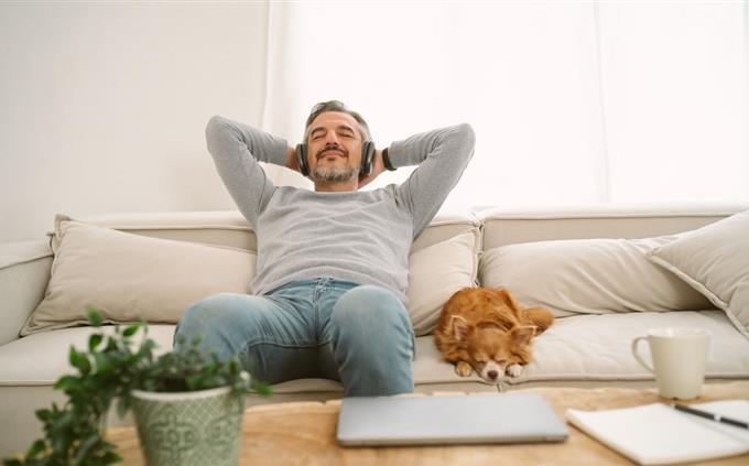 O que seus hábitos de sono revelam sobre seu futuro: um homem em um sofá com um cachorro