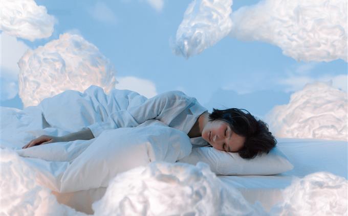 O que seus hábitos de sono revelam sobre seu futuro: uma mulher dorme pacificamente cercada por nuvens